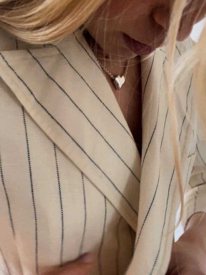 a model wearing a simple silver heart pendant