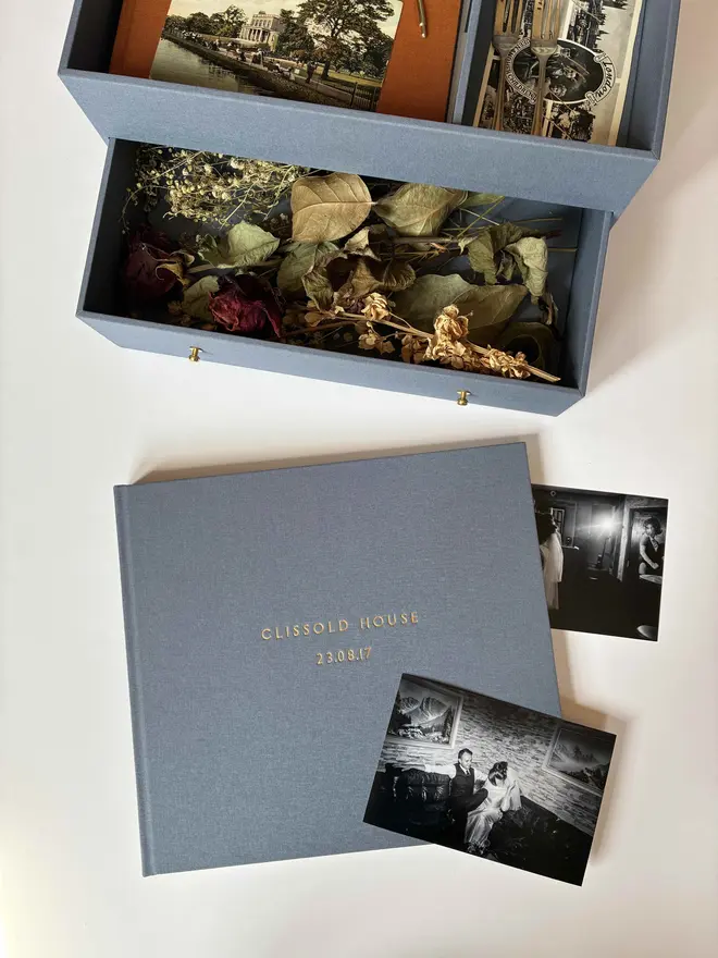 Handmade wedding keepsake box open to display contents alongside a handmade photograph album