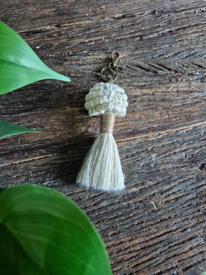 Handmade macrame mushroom keyring with a whimsical design, perfect accessory for adding a playful touch to bags or keychains