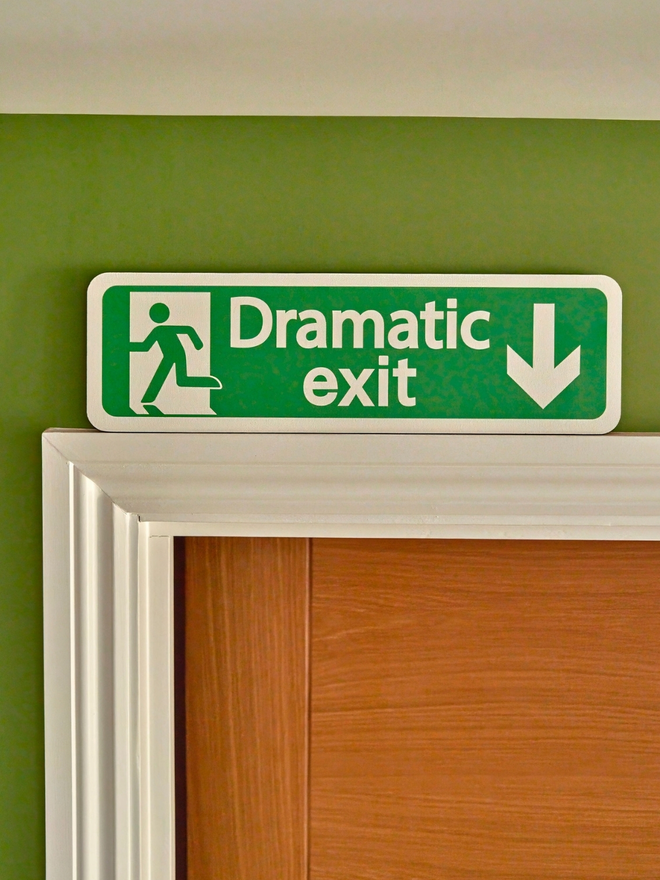 Green dramatic exit sign. A sign which looks like an exit sign saying dramatic exit