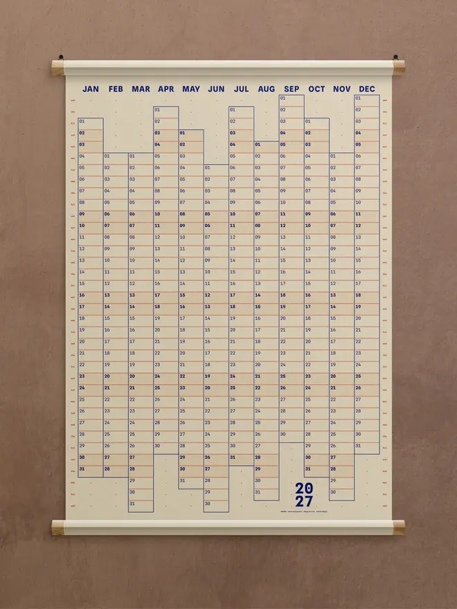 A natural 'clay' Dotline 2027 yearly wall planner on brown wall