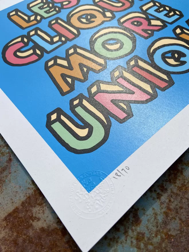  "Less Clique More Unique" Hand Pulled Screen Print blue background with multi colour letters with black hand drawn outline that spell out less clique more unique