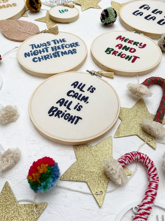 custom phrase embroidered christmas hoop. cotton hoop embroidered with assorted festive phrases.
