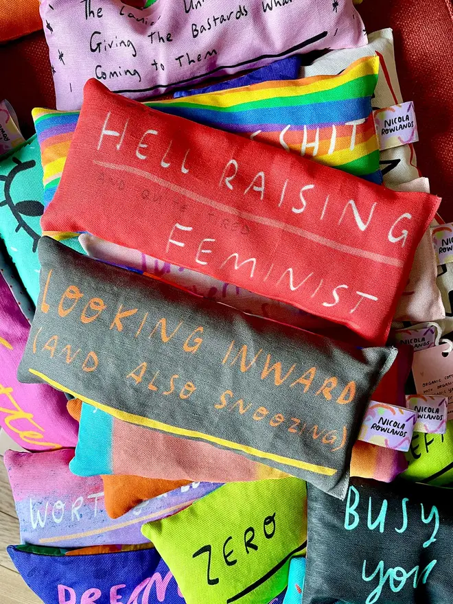 Colourful red lavender eye pillow which reads 'hell raising feminist'