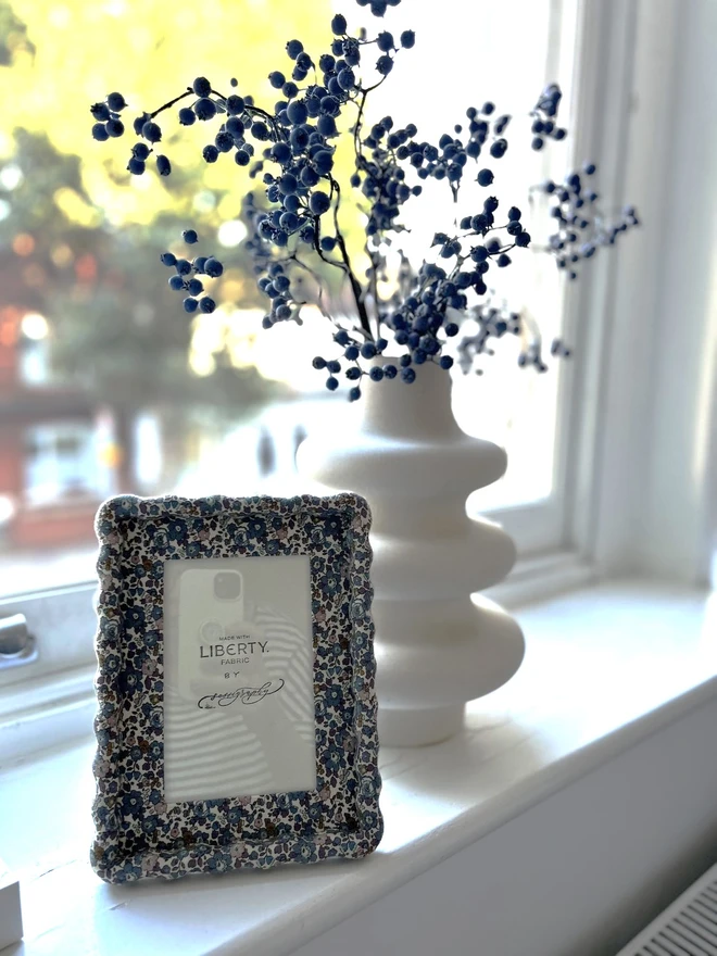 Liberty fabric covered wiggle mount frame displayed on windowsill