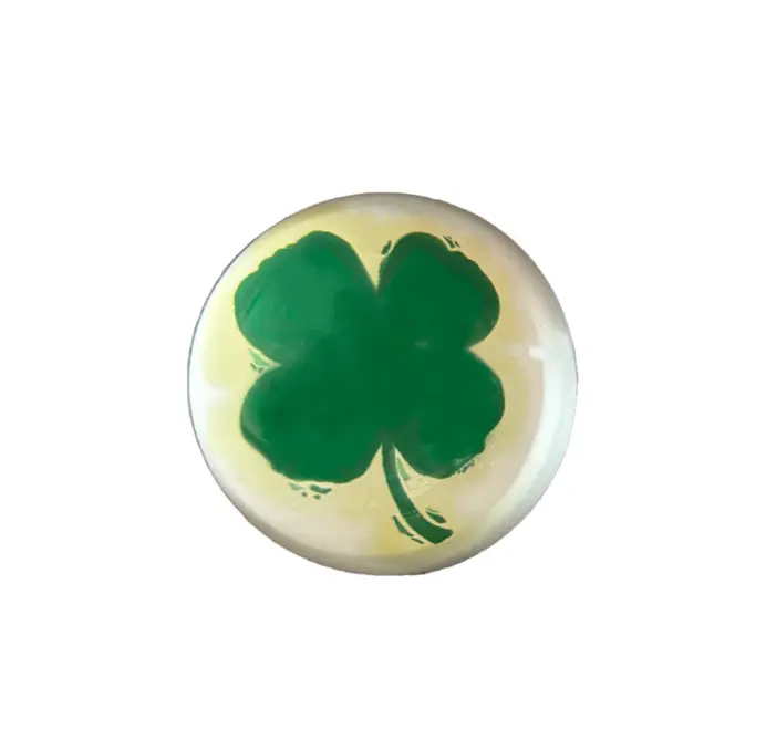 Round green clover paperweights on a white background. 