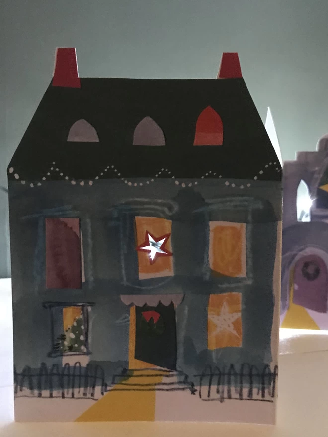 Festive Street illustrated custom-shaped concertina card. Light shines from behind and through tiny cut-out windows.