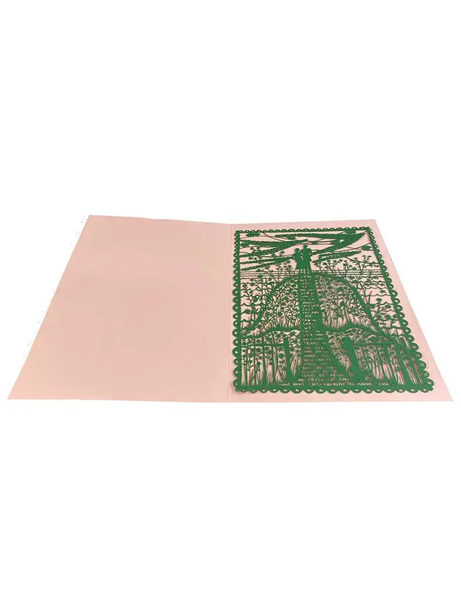 An intricate green lasercut on a white background. Lasercut image of two people atop a hill with text on the hill about future dreams in a pink folder