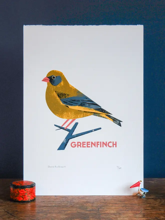 illustrated greenfinch print. illustrated greenfinch print propped up against navy wall background.