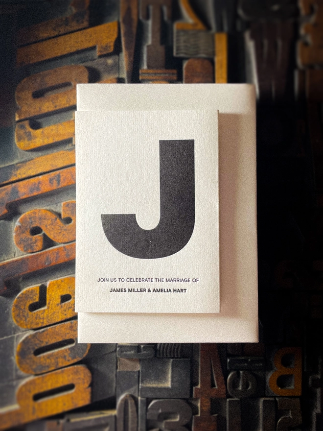 Minimal black and white personalised letterpress Save the Date with oversized initial, hand printed on luxury GF Smith Colorplan Pristine White 350gsm card with matching envelope.