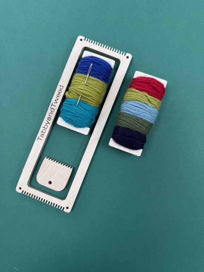 beige rectangular loom with two spools of bright yarn