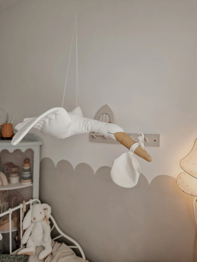 Flying Stork Hanging Decoration, a hanging stork decoration suspended in a child's bedroom. 