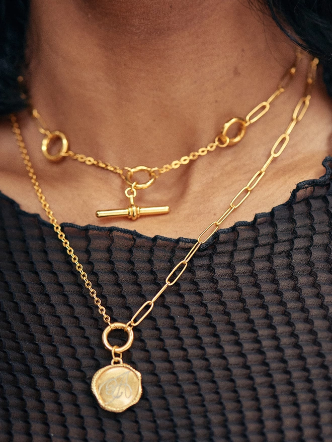 Woman wearing gold necklaces with charms and pendants