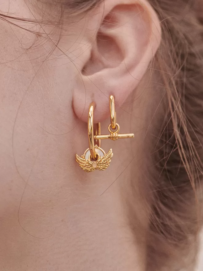 woman wearing gold hoops with charms