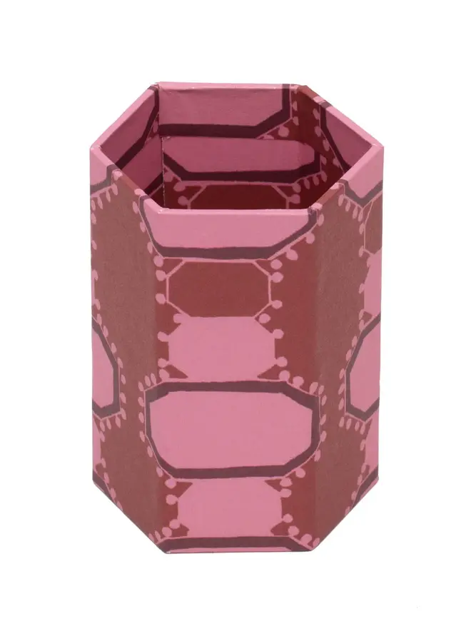 Hexagonal Brush Pot, a colourful patterned pencil pot sitting on a white surface against a plain backdrop. 