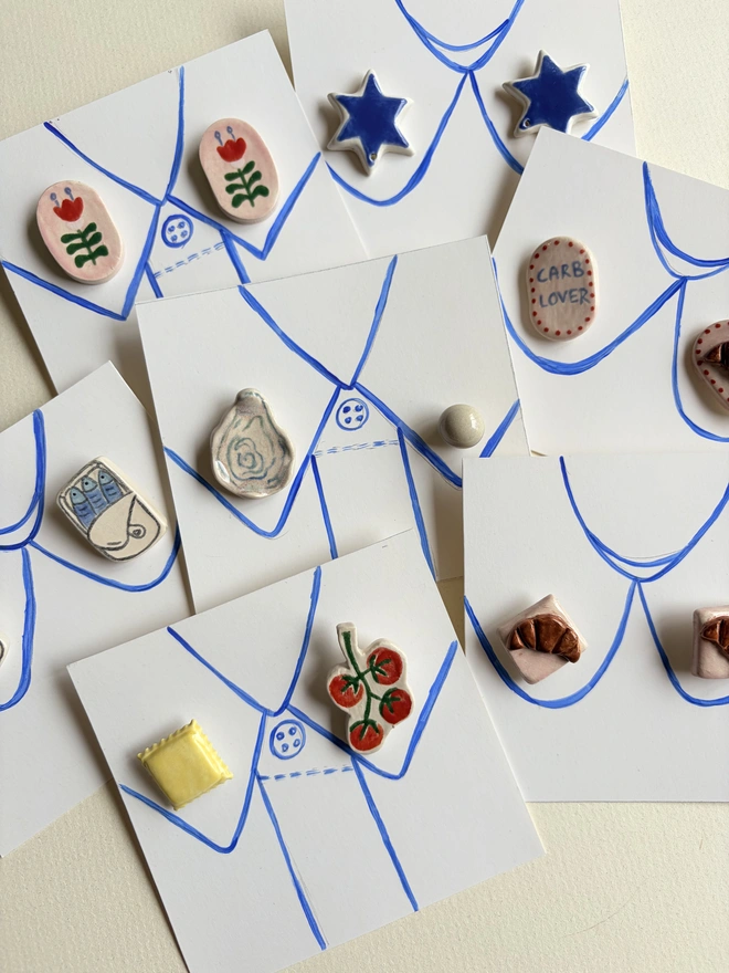 Foodie Collar Pins. A selection of collar pin sets like tomatoes and ravioli, sardine tins and oyster and pearl on a faux paper collar