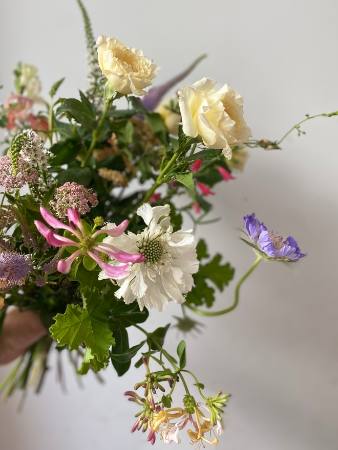 English garden bouquet flower box featuring a wild, hand-tied mix of pastel and bright seasonal blooms, including scented roses, mint, and soft garden foliage, freshly picked in Hampshire for July.