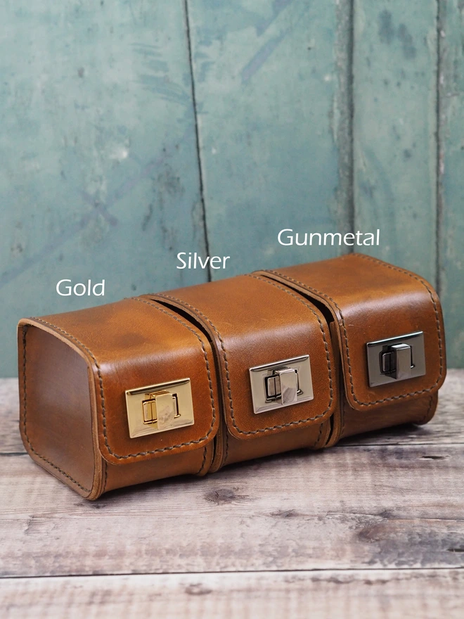 Personalised leather watch carry case. Three handmade leather tan brown watch cases, each with different coloured clasp. Gold, Silver and Gunmetal grey colours.