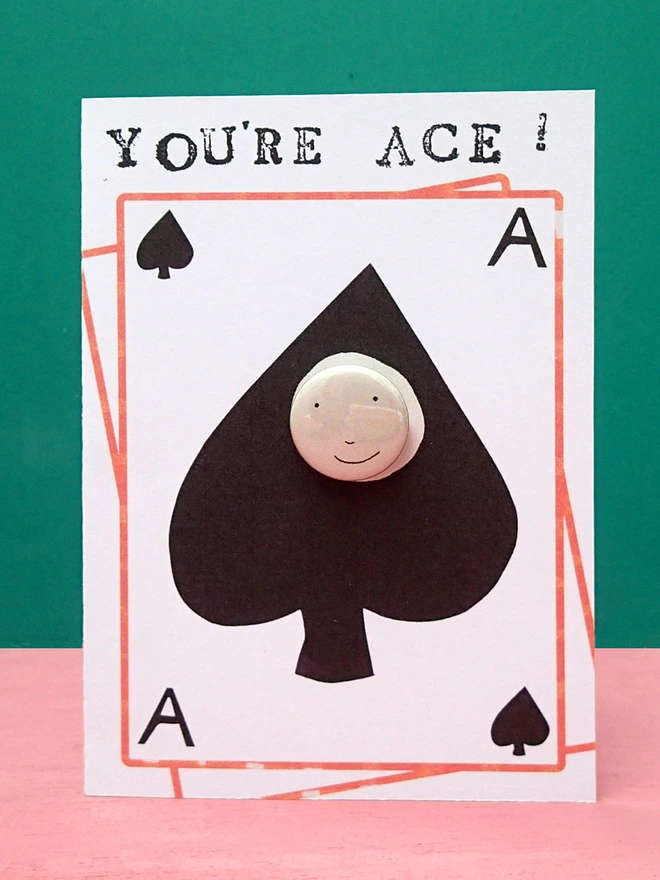 ace of spades greeting card with happy face pin badge