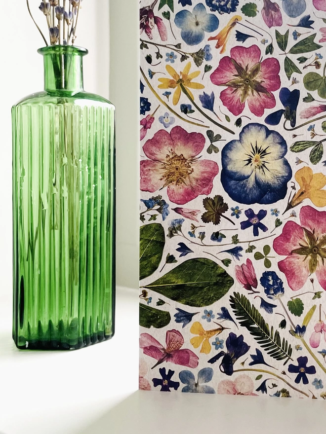 Close-Up of Digitally Printed Greetings Card Showing Intricate Detail of Pressed Flowers - Standing on Windowsill with Green Glass Bottle Containing Dried Lavender