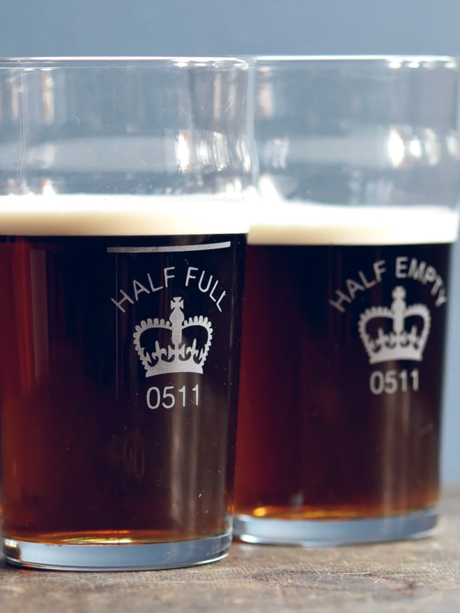 Half Full / Half Empty Pint Glass. Two half empty pint glasses with engravings.