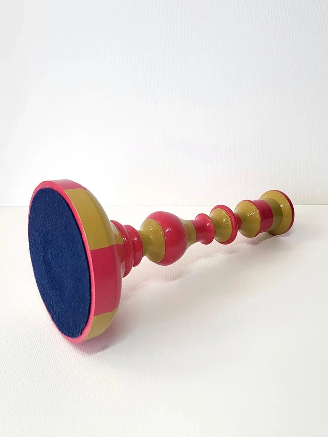 underside view of  wooden candle stick holder, hand painted in pink and mustard yellow stripes
