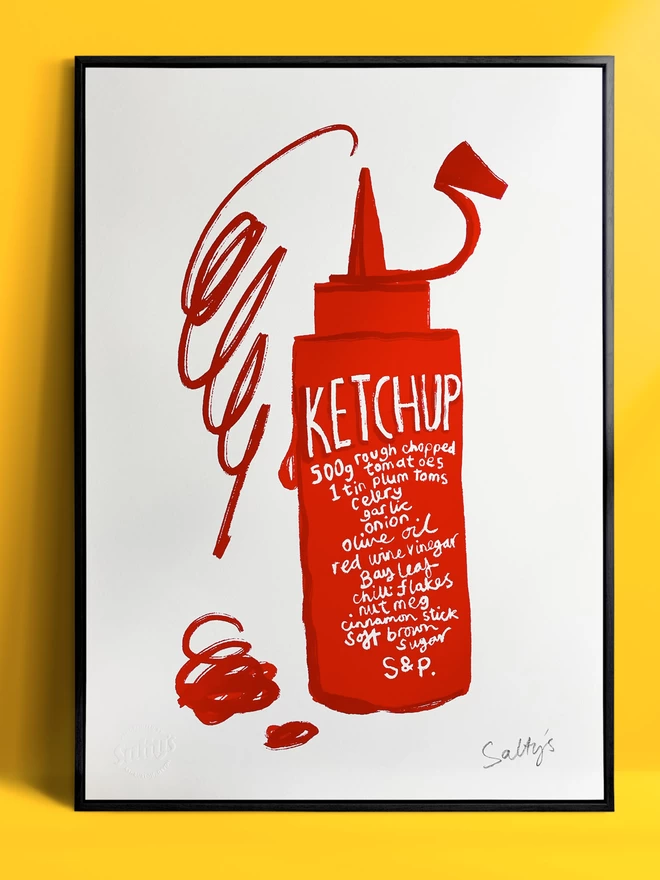 Framed print of a bottle of ketchup on white A3 paper, a cafe style ketchup dispenser has a recipe for ketchup written on the side and a big scribble of ketchup squirting out of the top. This framed print is leant against a yellow wall.