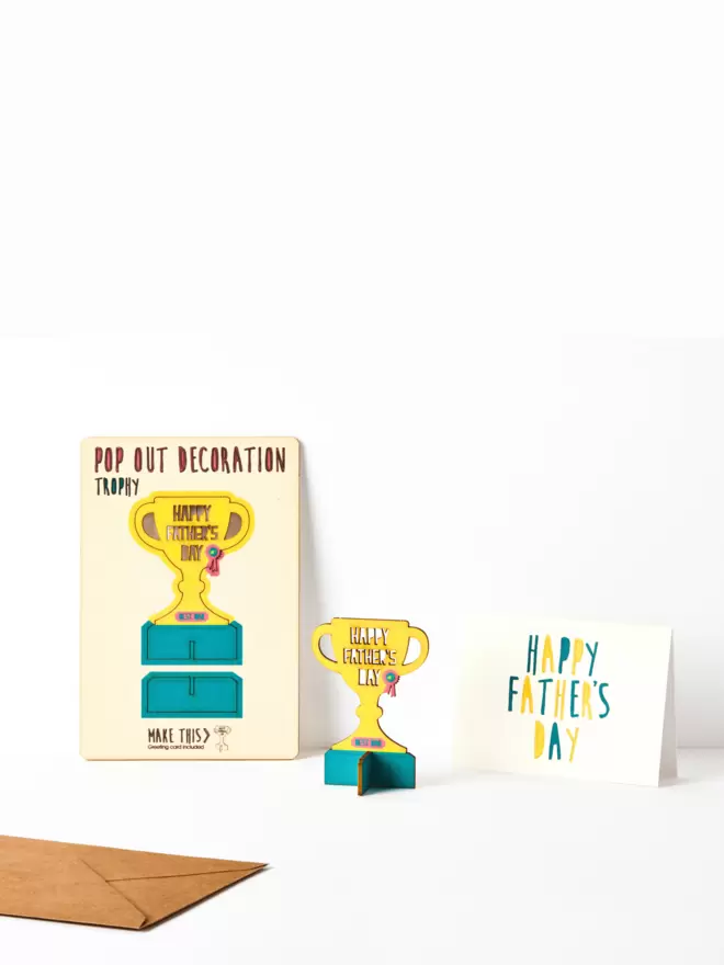 Happy Father's Day trophy decoration and Happy Father's Day card and brown kraft envelope on a white background