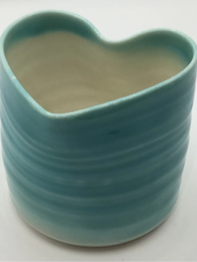 porcelain heart shaped tea light holder. a tea light holder glazed in turquoise on the outside and white on the inside.