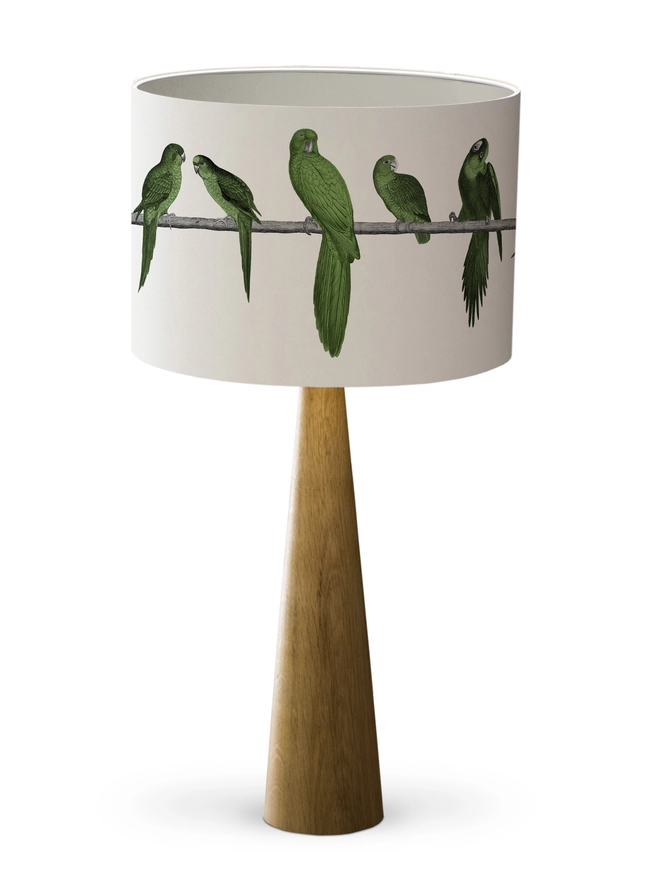 Drum Lampshade featuring Green Parrots with a white inner on a wooden base on a white background