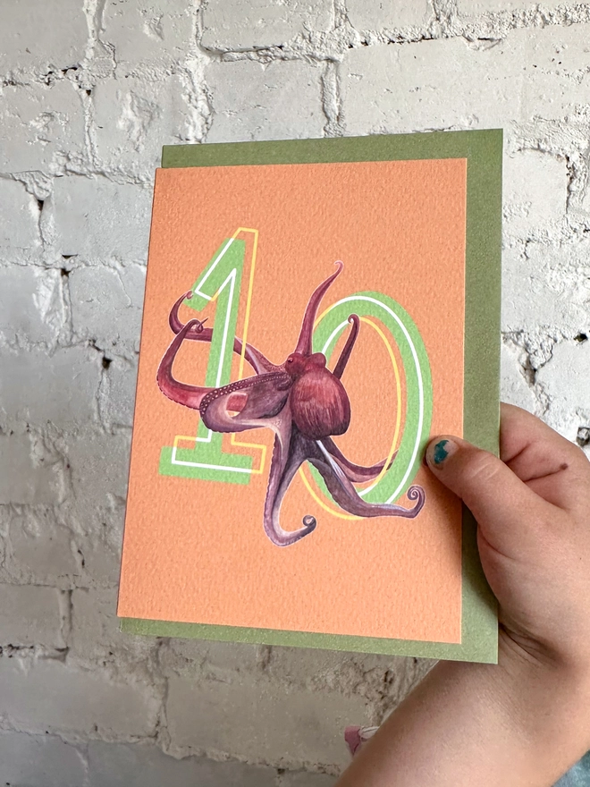 Bright orange card with a big green number 10 and octopus illustration with a green envelope