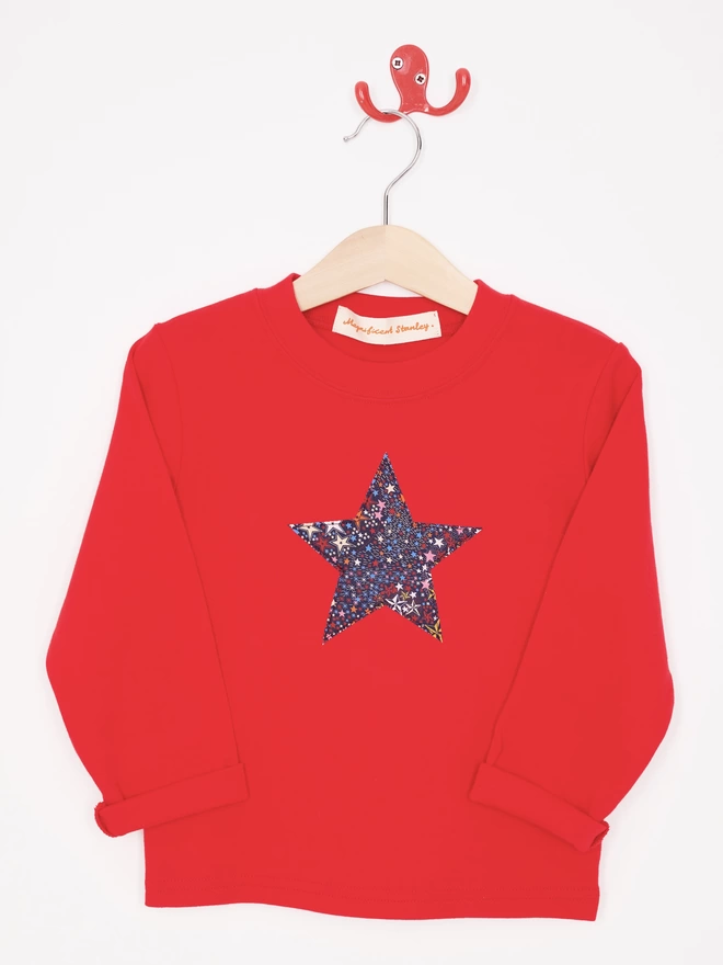 A red tee with a Liberty star print star sewn on the front