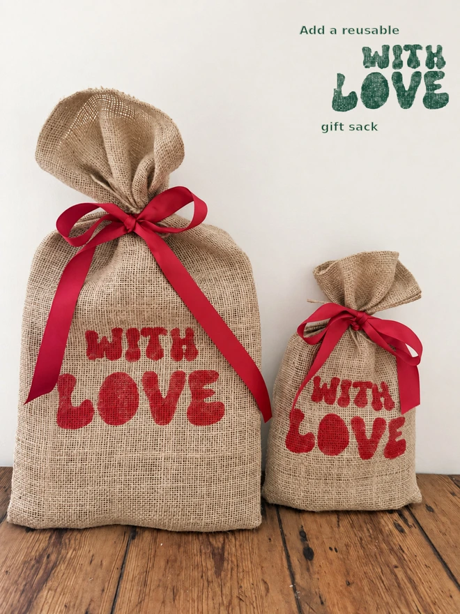 Large and small reusable jute gift sacks tied up in red ribbon and hand printed WithLove in red