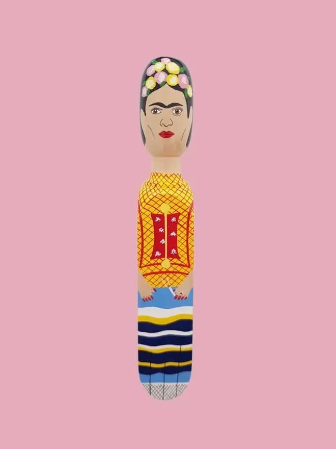 Wooden Door Stopper (Freeda Floral Crown Outfit), a colourful wooden door stop sitting on a white surface. 