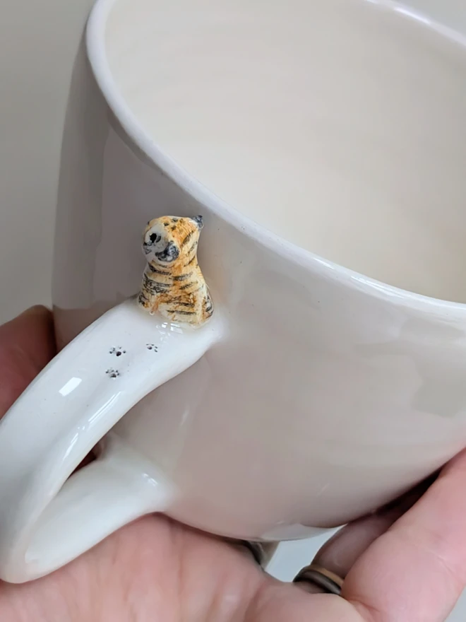 Handmade hello tiger cup in white earthenware ceramic with a tiny stripy cat and hand painted words