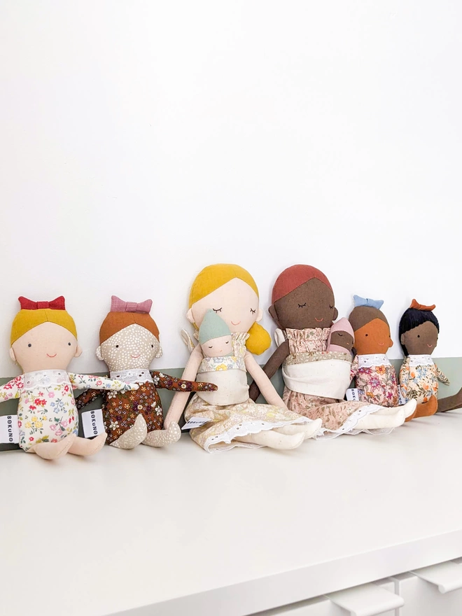 collection of mother, child and baby dolls in different skin tones
