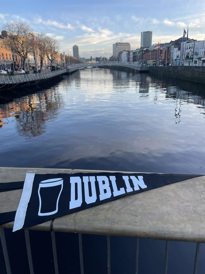 a felt pennant flag black and white, it has the word DUBLIN written in the varsity style and a pint of Guiness next to it