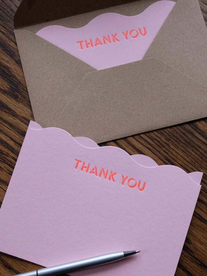 Pink wavy notecard with 'Thank you' printed across the top in neon ink. 