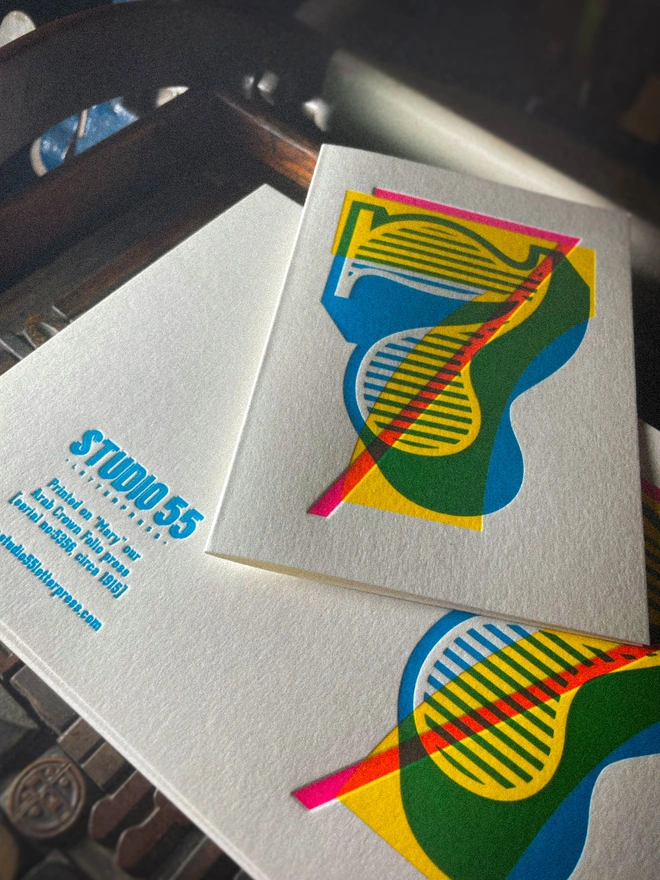 Handmade letterpress 7th birthday card featuring bold overlapping numerals printed in vibrant fluorescent cyan, magenta and yellow inks. Each card is individually hand printed using traditional letterpress techniques on luxury paper stock, creating a beautifully tactile finish with a deep impression and rich layered colours inspired by the CMYK printing process. Printed on a traditional letterpress from 1915. A wonderful artisan printed birthday card.
