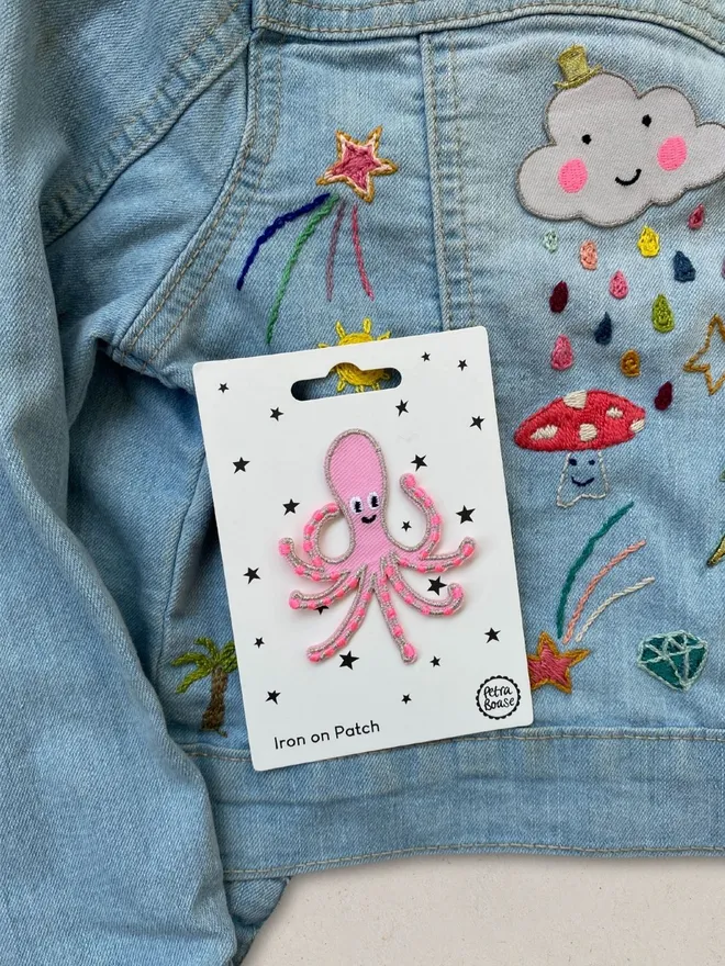 Pink octopus embroidered iron on fabric patch on a kids customised denim jacket.