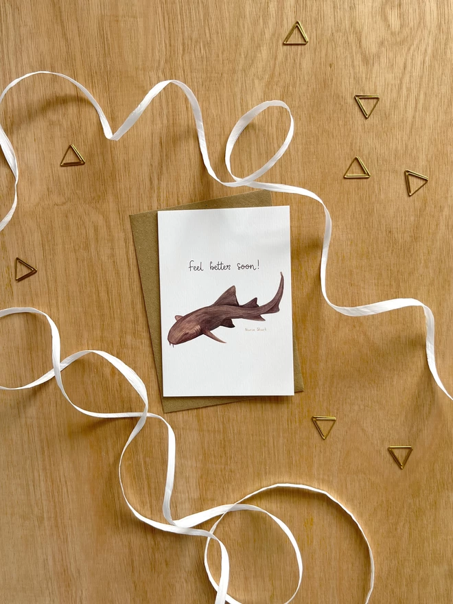 a greetings card featuring a nurse shark and the phrase “feel better soon”