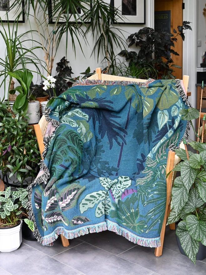 Indoor Jungle Window laid out over a sofa seen in a room filled with plants.