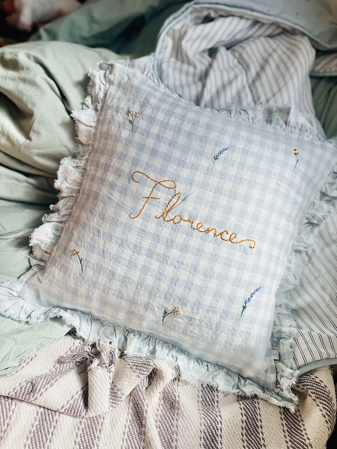 Blue gingham linen cushion with hand embroidered ditsy florals and personalised name