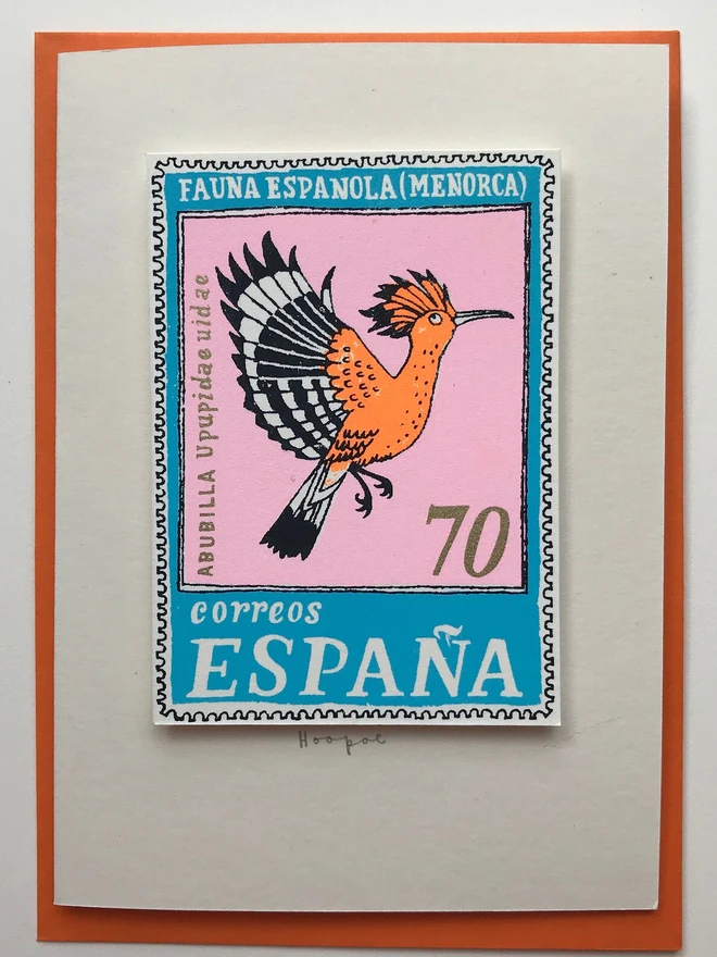 Bird Stamp Card Spain/ Hoopoe Card, a white card with a bird design in the middle against an orange envelope on a white background. 