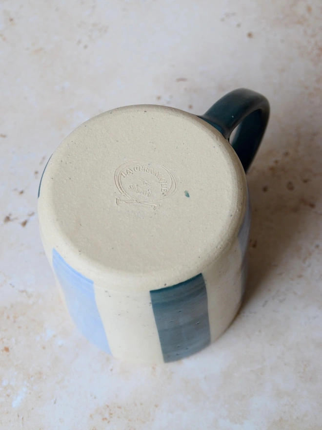 Bonbon Mug — base view showing blue and cream striped design with maker’s mark