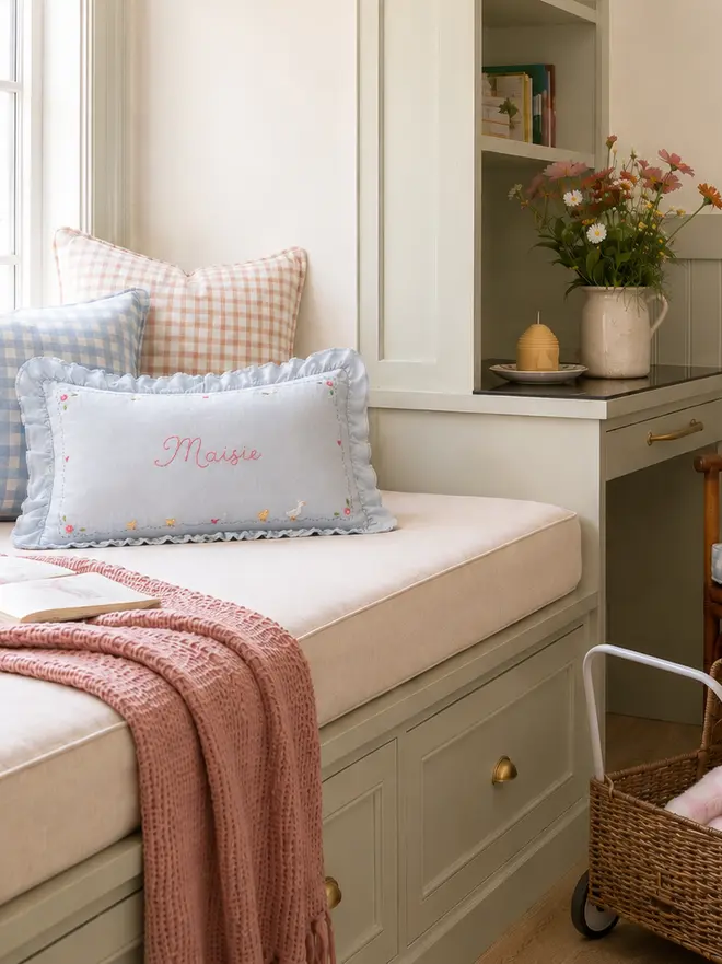 Hand Embroidered blue linen cushion with ruffle trim in girls bedroom window seat 