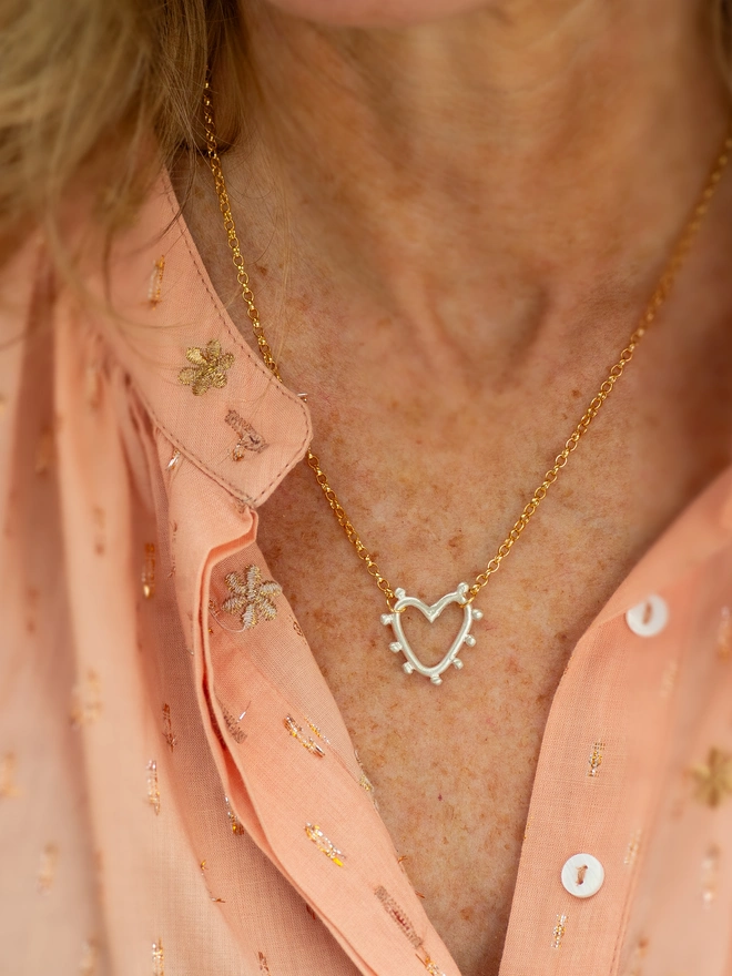 The Mini Studded Heart Necklace blends soft texture with timeless design. A delicate studded heart hangs from a classic belcher chain, creating a mixed metal necklace made for effortless everyday wear. Designed to layer beautifully or shine solo, it’s a modern heart necklace full of meaning and sentiment.