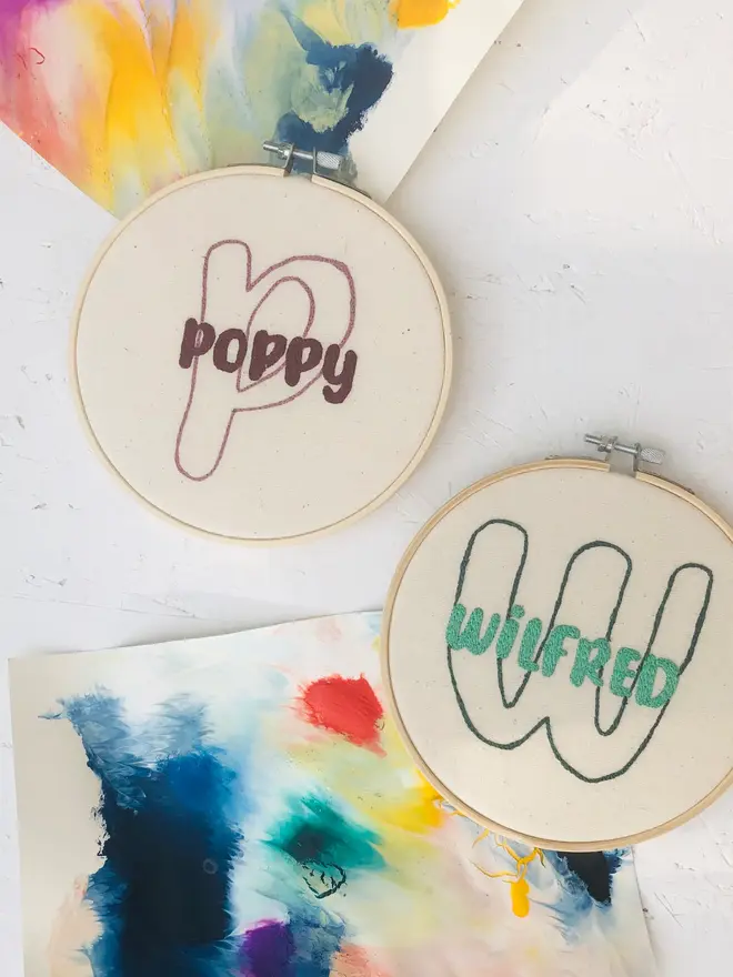 personalised name and initial embroidered hoop. two cotton hoops embroidered with names poppy and wilfred respectively.