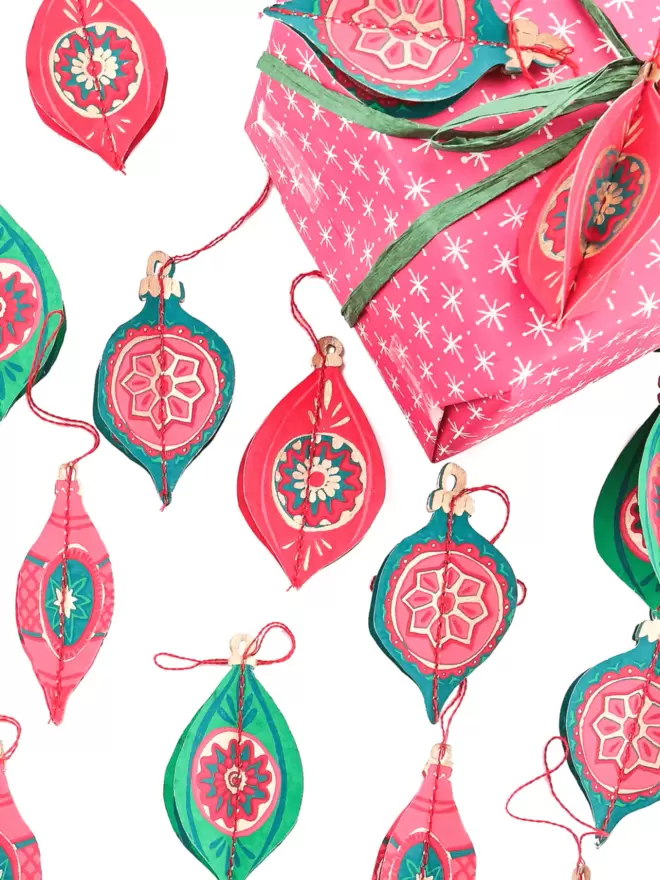 Christmas set-up with brightly packaged gifts and beautiful, pink, green and gold detailed babubles