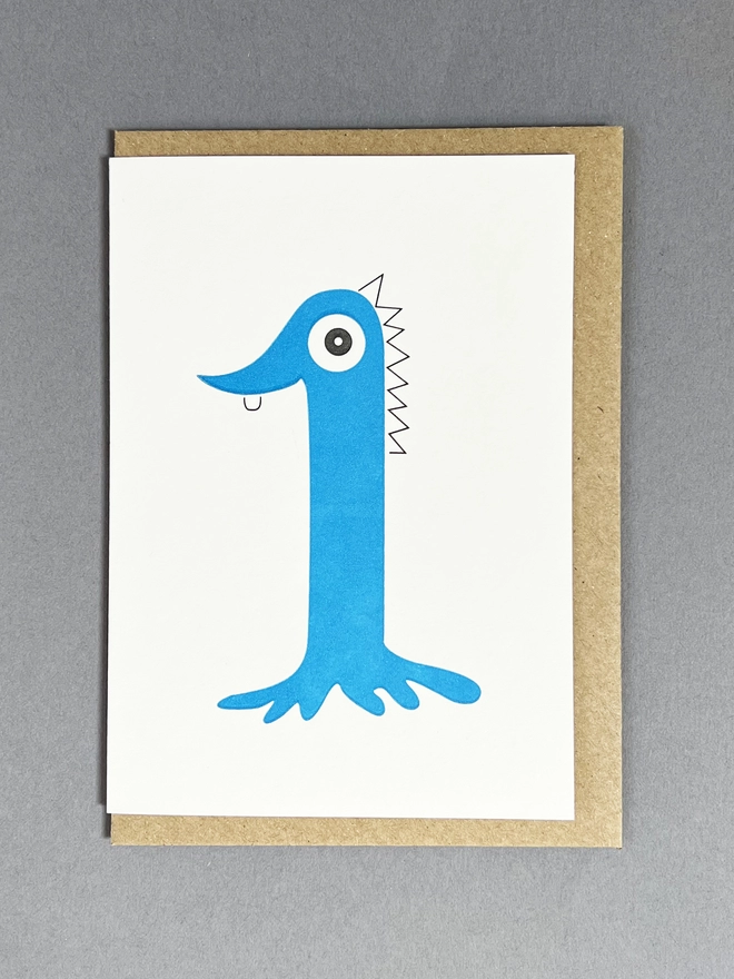 Playfully drawn letterpress printed blue number one with one eye and one tooth